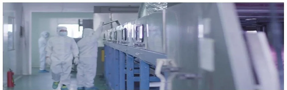 Gowned staff walking the corridor of the Class 300,000 clean workshop