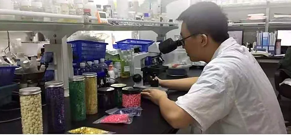 Formulation engineer reading a wax sample on a microscope stage at the BeauTome bench