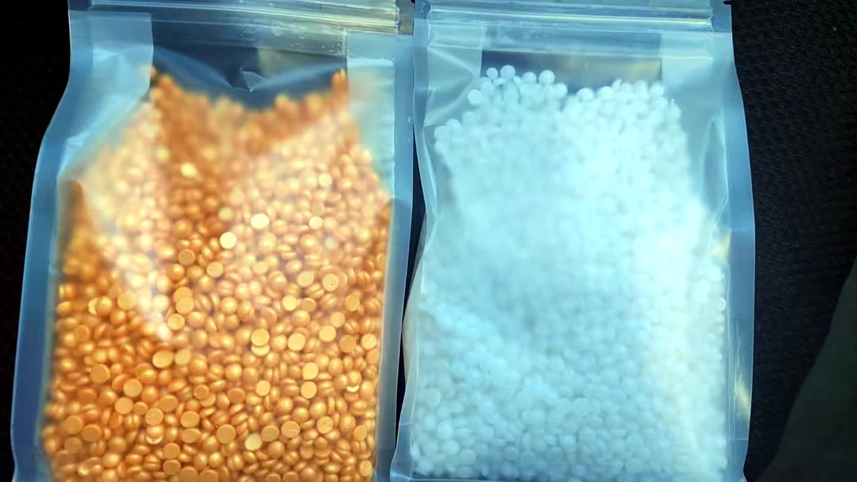 BeauTome rosin-free hard wax beads in gold and white — real production shot in unlabeled transparent bags ready for private label