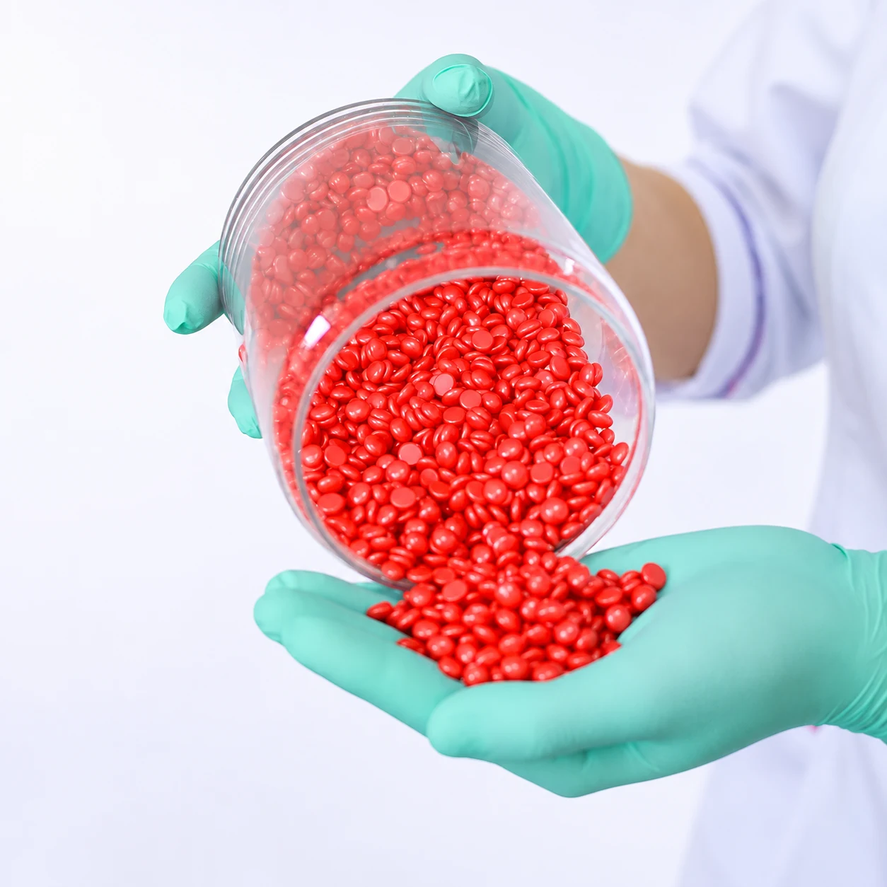 BeauTome lab — technician pouring red hard wax beads for formula evaluation